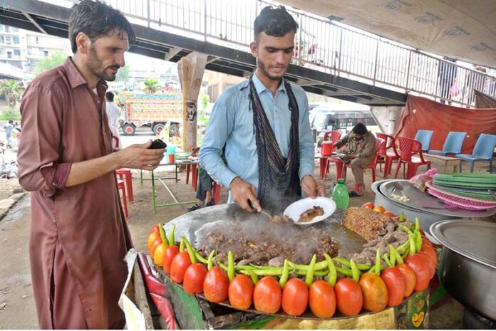 A vendor busy in frying ‘Tawa Kaleji’ for customers at his roadside setup